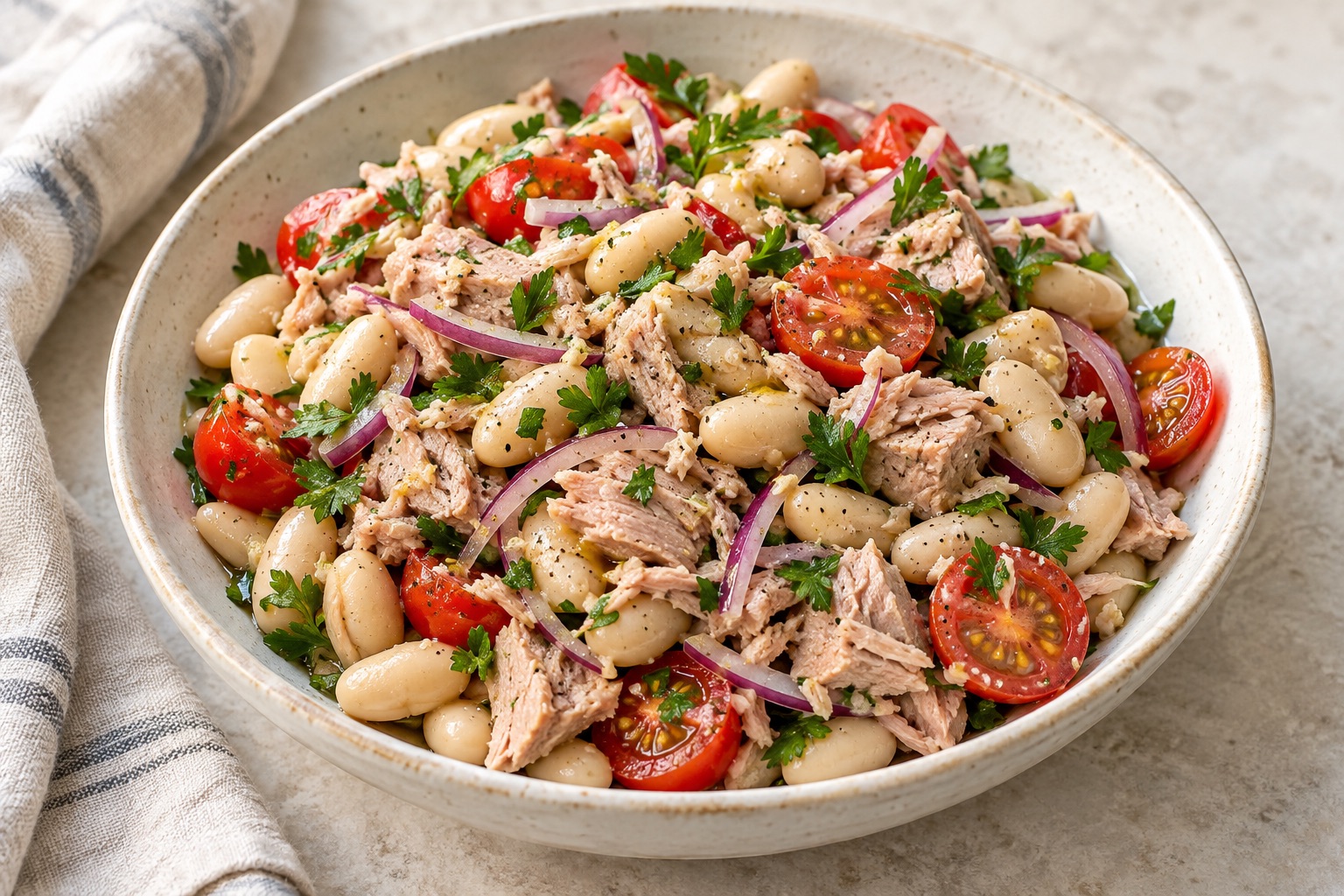 Illustration of tuna, cannellini beans, cherry tomatoes, red onion and parsley in a salad bowl.